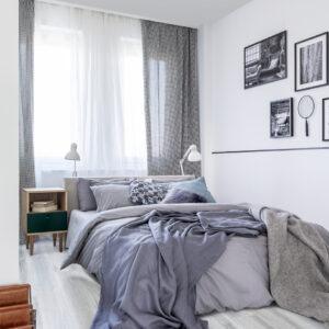 Grey sheets on bed and patterned drapes at window in bedroom int Oak Duna Grey